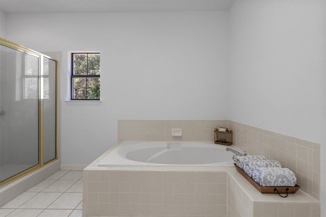 Bathroom with a shower stall, a bath, and tile patterned flooring | Image 21