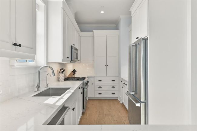 The kitchen features Viking appliances, quartz counters, and plenty of cabinet space. | Image 16