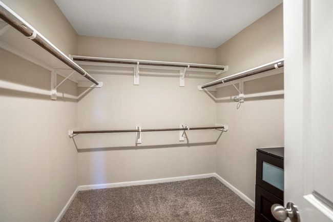 A large walk in closet offers lots of hanging space in the primary bedroom suite. | Image 26