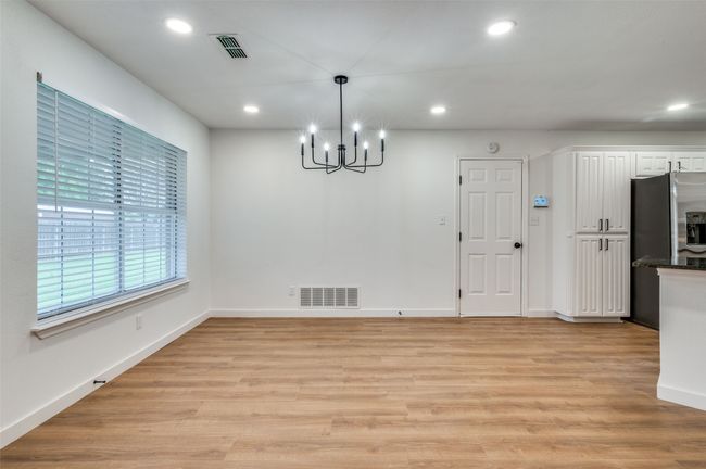 Unfurnished dining area featuring a notable chandelier, visible vents, and recessed lighting | Image 15