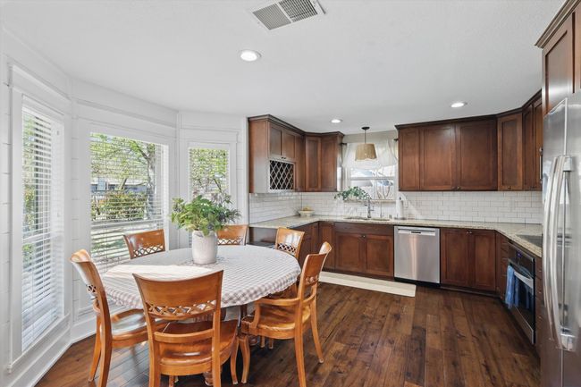 Kitchen with stainless steel appliances, dark wood finished floors, tasteful backsplash, healthy amount of natural light, and recessed lighting | Image 11