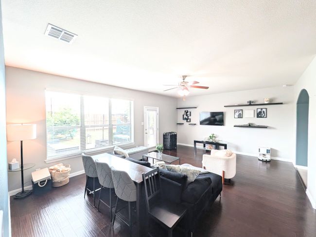 Living area featuring a ceiling fan, dark wood-type flooring, and arched walkways | Image 18