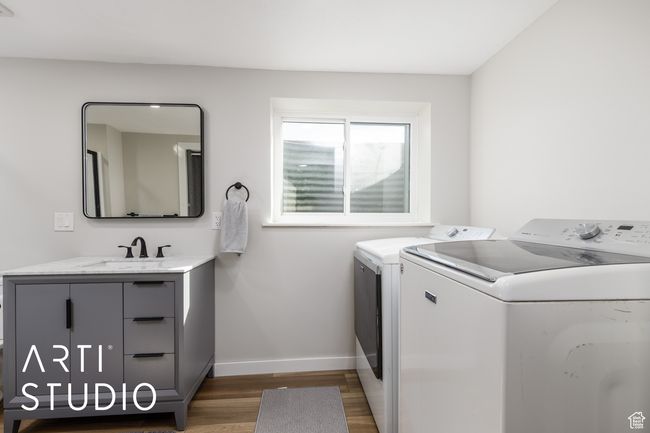 Laundry area featuring wood finished floors, a sink, washing machine and clothes dryer, baseboards, and cabinet space | Image 30