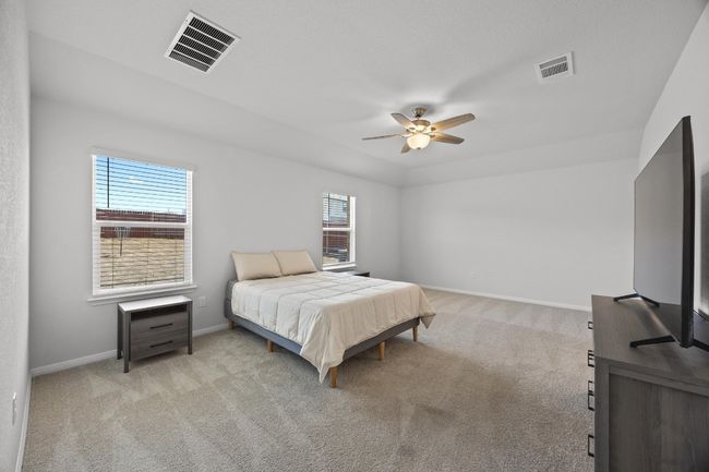 Primary bedroom with light colored carpet and a ceiling fan | Image 17