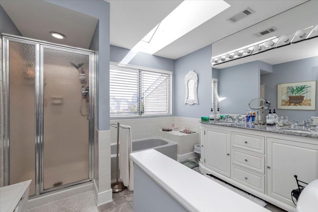 Bathroom featuring a skylight, a sink, and visible vents | Image 12