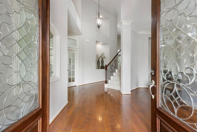 Stately double door entry with formal dining room on right and study across from staircase. First room to left at entry is a flex room with picture frame window. | Image 5