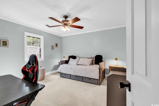 Carpeted bedroom featuring crown molding, a ceiling fan, and a textured ceiling | Image 25