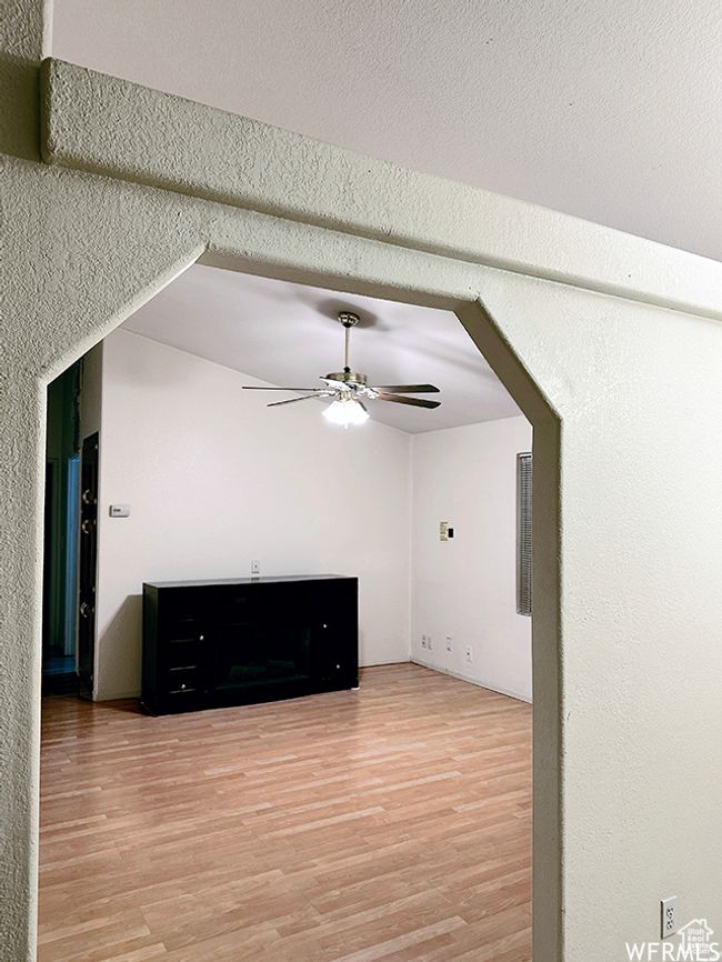 Unfurnished living room with a textured ceiling, ceiling fan, and light wood-type flooring | Image 38