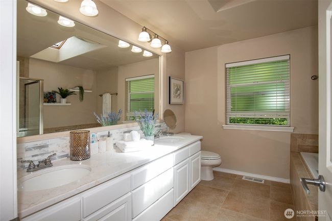 Primary Bath with Double Sinks, Stone Counters, Soaking Tub & Separate Shower & Tile Floors. | Image 23