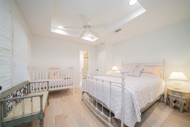 Bedroom with a raised ceiling, wood finished floors, recessed lighting, and ceiling fan | Image 26