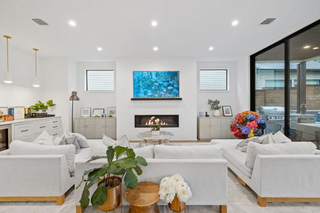Living room featuring a glass covered fireplace and recessed lighting | Image 15