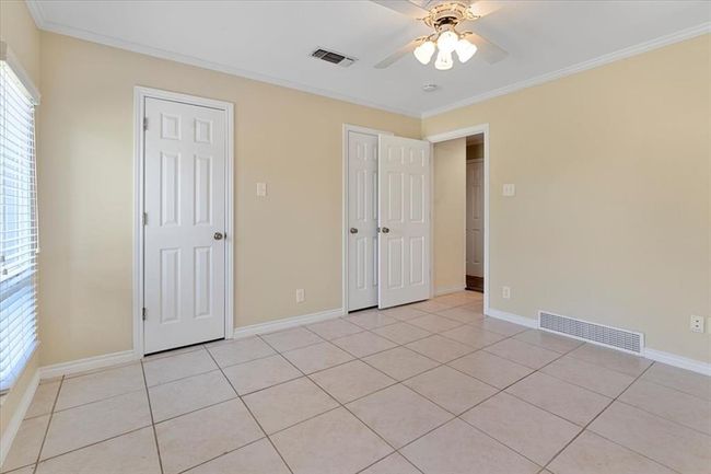 Unfurnished bedroom featuring light tile patterned floors, ceiling fan, and crown molding | Image 20