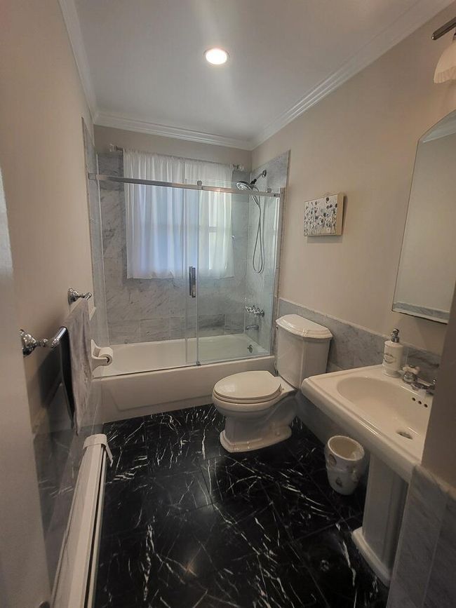 Bathroom with toilet, marble finish flooring, shower / bath combination with glass door, crown molding, and recessed lighting | Image 38