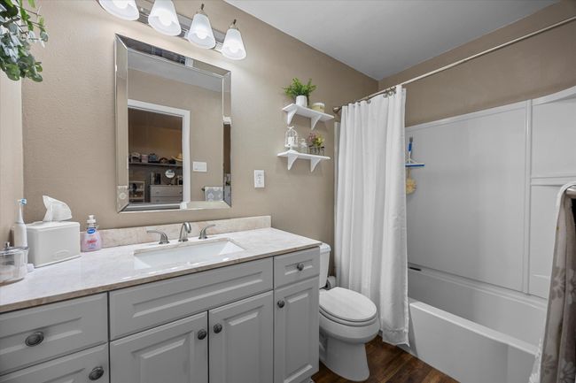 Bathroom featuring vanity, wood finished floors, and shower / tub combo | Image 17
