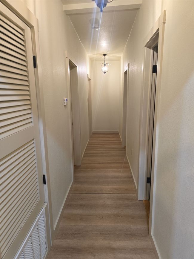 Hallway featuring wood finished floors and baseboards | Image 7
