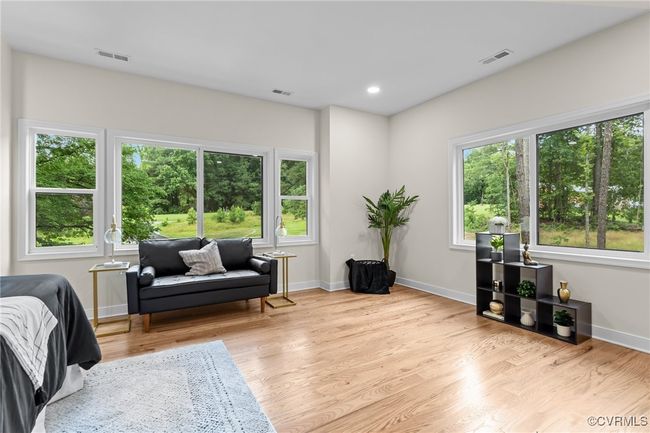 Living area with healthy amount of natural light and wood finished floors | Image 35
