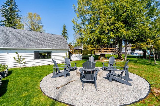 View of yard featuring fence, a fire pit, a patio area, and a playground | Image 29