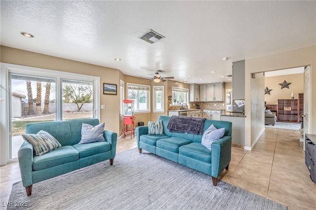 Living room featuring light tile patterned floors, a ceiling fan, baseboards, and a textured ceiling | Image 16