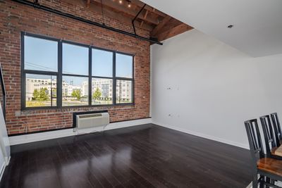 Living space with vaulted ceiling and exposed brick wall | Image 3