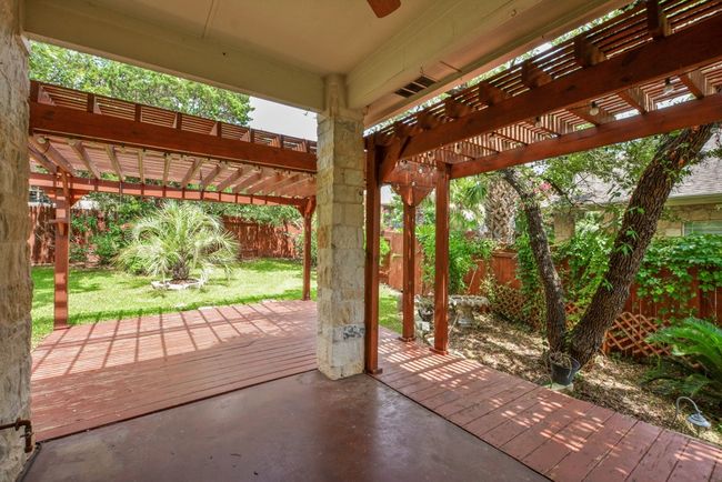 Step outside to your private backyard haven, where a pergola-covered deck and patio create the ideal setting for al fresco dining, morning coffee, or relaxing under the Texas sky. | Image 37