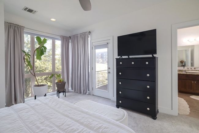 Bedroom with multiple windows, light carpet, visible vents, and access to exterior | Image 15