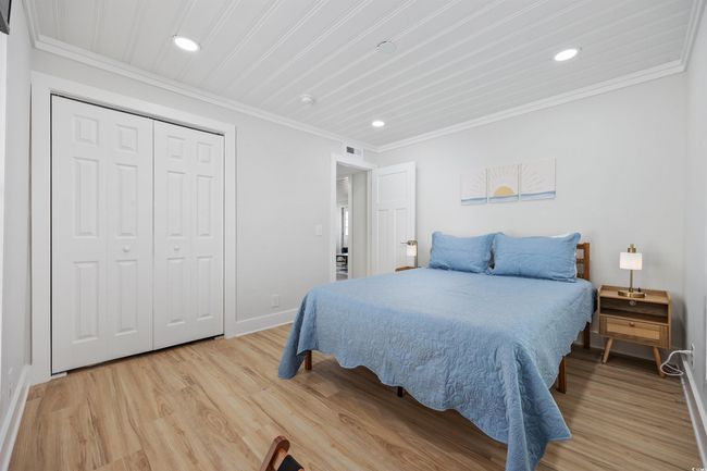 Bedroom featuring recessed lighting, baseboards, light wood finished floors, crown molding, and a closet | Image 26