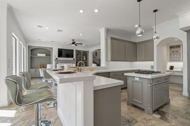 Gourmet Kitchen featuring a spacious island with pendant lighting, perfect for meal prep or casual dining. Sleek quartz countertops offer both elegance and practicality. | Image 10