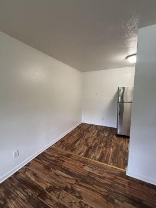 Empty room featuring baseboards and dark wood-style floors | Image 6