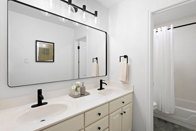 Secondary bathroom with dual vanity, updated flooring, fixtures, and lighting. | Image 18