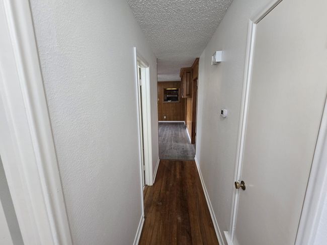 Corridor with dark wood-type flooring and a textured ceiling | Image 10