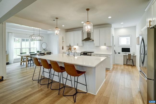Stunning kitchen features white cabinetry and quartz counters. | Image 14