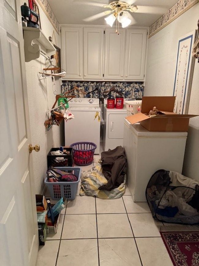 Washroom featuring washing machine and clothes dryer, cabinet space, a ceiling fan, and light tile patterned flooring | Image 15