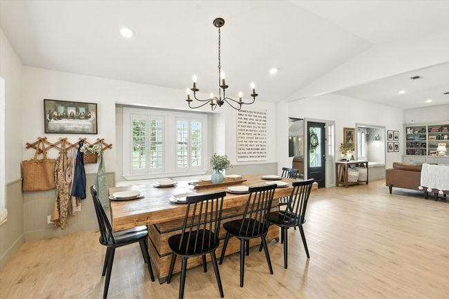 Dining room featuring lofted ceiling, recessed lighting, healthy amount of natural light, light wood-type flooring, and a chandelier | Image 9