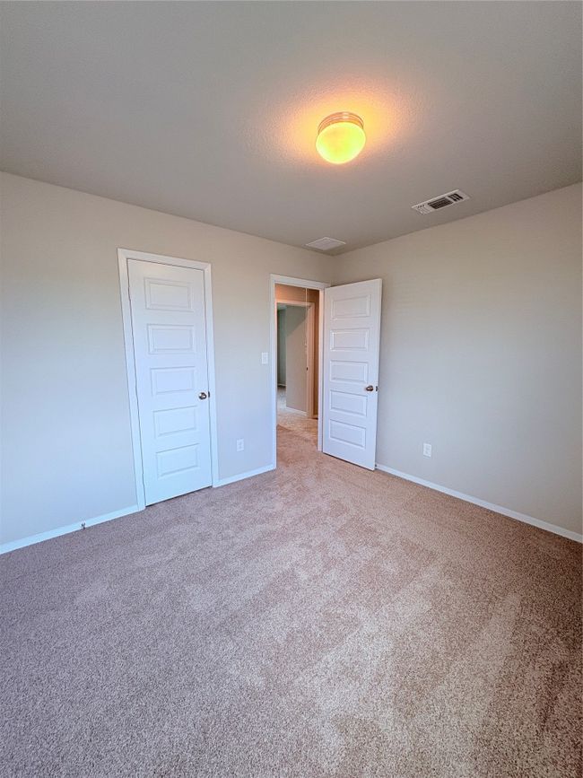 Unfurnished bedroom featuring light carpet, visible vents, and baseboards | Image 24