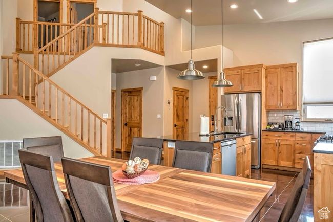 Dining room featuring stairway, recessed lighting, dark tile patterned floors, and a high ceiling | Image 5