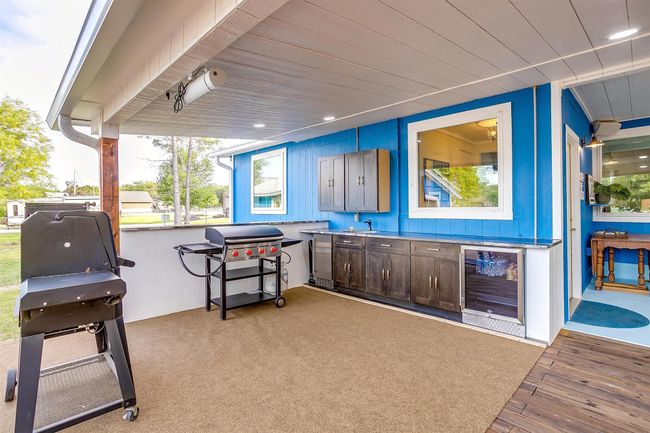View of patio with beverage cooler, a grill, and a sink | Image 6