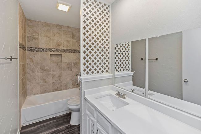 Bathroom featuring toilet, vanity, wood finished floors, and washtub / shower combination | Image 19