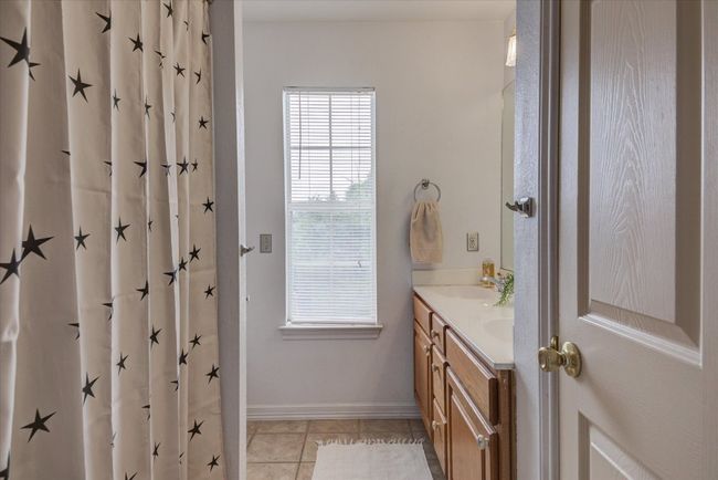 Shared upstairs bathroom has tile floors a bath/shower combo a double vanity, and linen closet. | Image 20