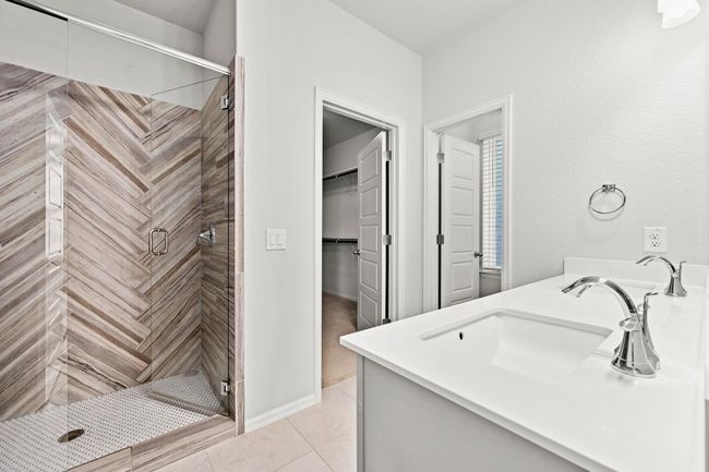 Full bathroom featuring a shower stall, vanity, and a walk in closet | Image 22
