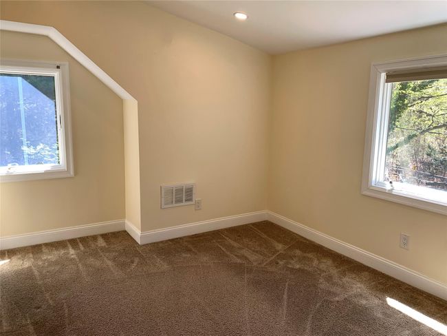 Spare room with baseboards, visible vents, and dark colored carpet | Image 14
