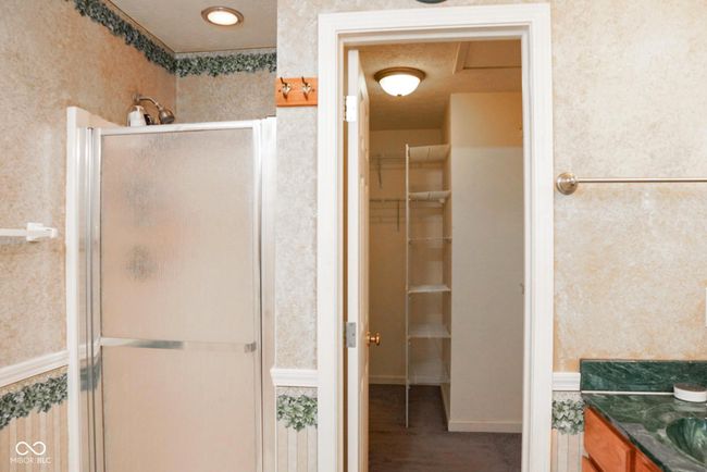 bathroom featuring a shower stall, a spacious closet, vanity | Image 22