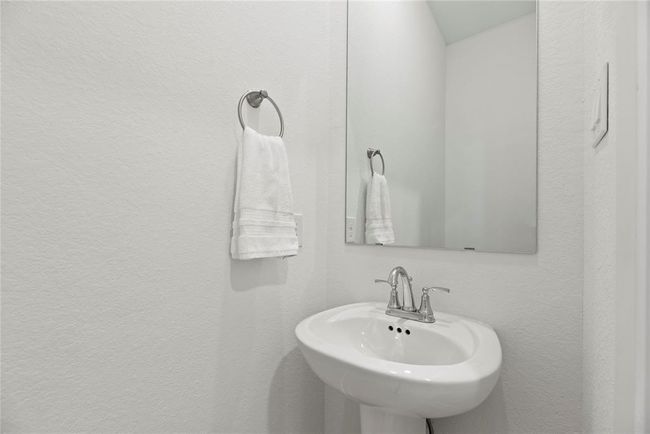 Downstairs half bathroom boasts a pedestal sink. | Image 20