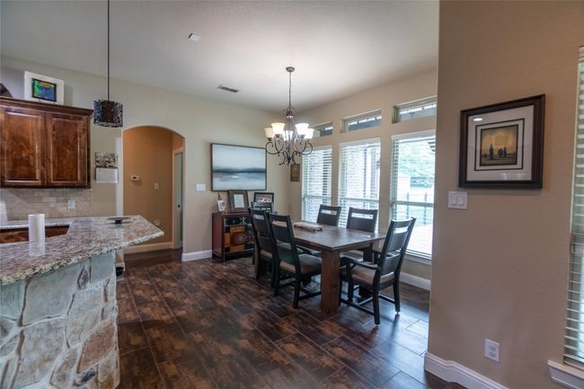 Dining room featuring arched walkways, baseboards, dark wood finished floors, and a chandelier | Image 13