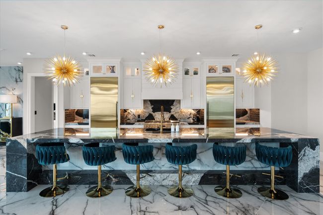 Kitchen with stainless steel built in fridge, an inviting chandelier, and a breakfast bar | Image 9