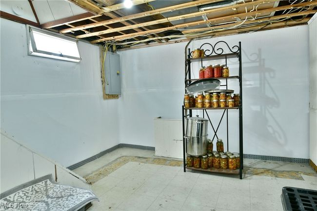 Basement featuring electric panel and tile patterned floors | Image 45