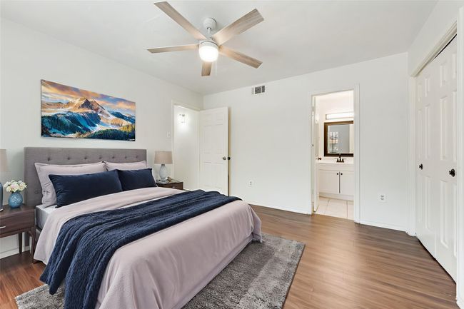 Virtually Staged Bedroom with wood finished floors, a ceiling fan, ensuite bathroom, and a closet | Image 12