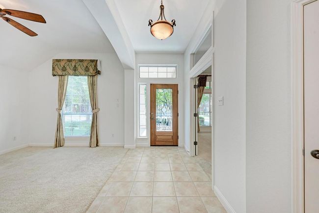 Foyer entrance with baseboards, a ceiling fan, light tile patterned flooring, and light carpet | Image 6