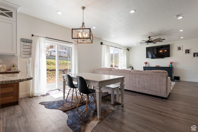 Dining room with recessed lighting, wood finished floors, a textured ceiling, and ceiling fan with notable chandelier | Image 15