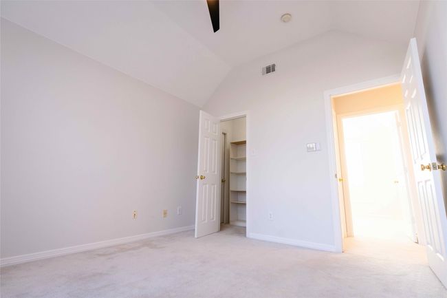 Unfurnished bedroom featuring lofted ceiling, light carpet, and a ceiling fan | Image 20