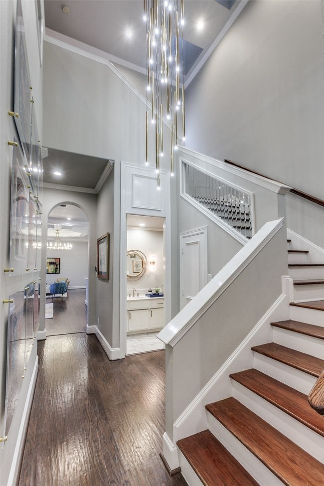 The staircase leading to the upstairs has a striking contemporary-styled chandelier cascading down to the first floor. A powder bath, seen here, serves the first floor areas, and there is a convenient storage area tucked away behind a door under the stairway. | Image 22